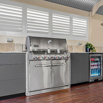 Diagonal view of BBQ, cabinets and fridge