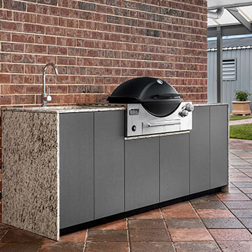 BBQ with sink in front of brick wall